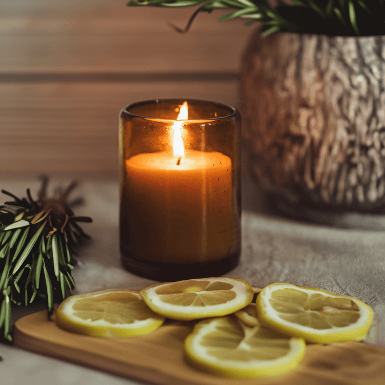 bluecorn candle burning in blown glass with lemons and apothecary items