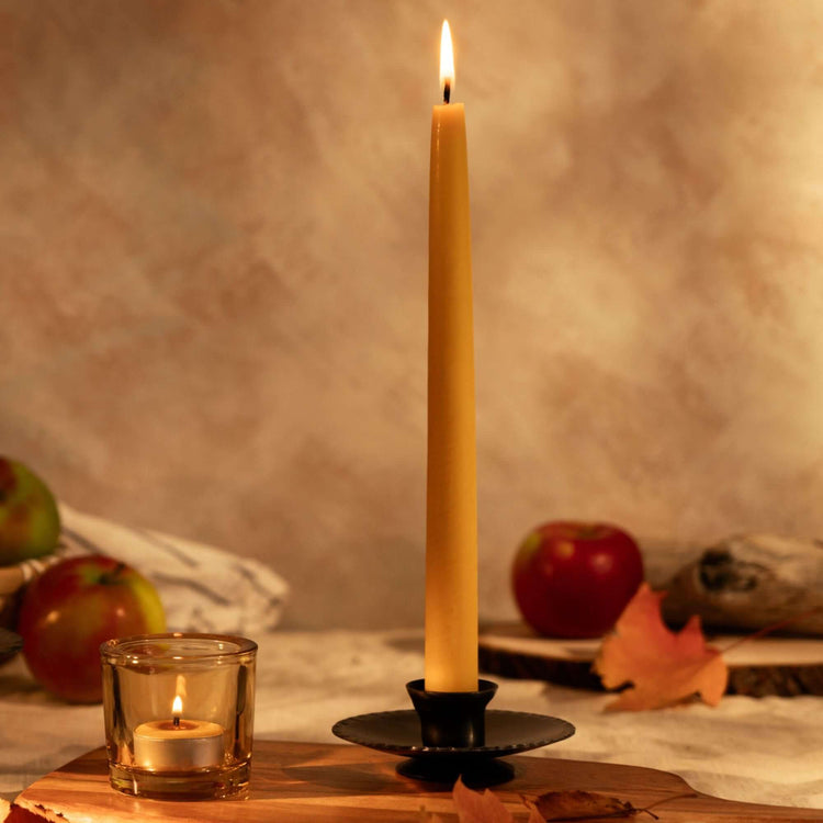 Taper Candle Holders with a hand-dipped beeswax taper candle in a handcrafted taper candle holder, surrounded by apples and leaves.