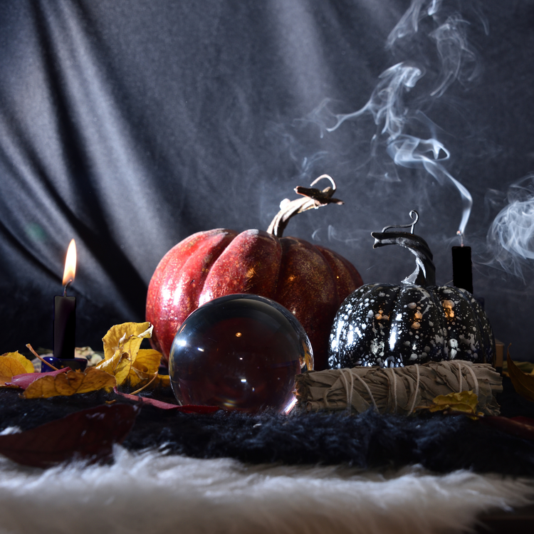 Black beeswax tapers beside a pumpkin, crystal ball and bundle of sage | Halloween Candles