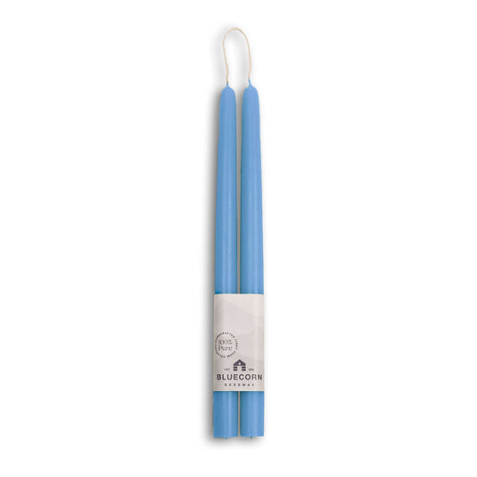Two blue beeswax taper candles in a white label with 'Bluecorn' branding on a white background