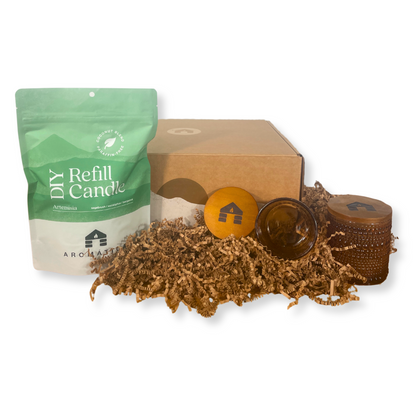 Artemisa scented DIY candle refill kit with packaging, candle wicks, and a glass container on a white background.