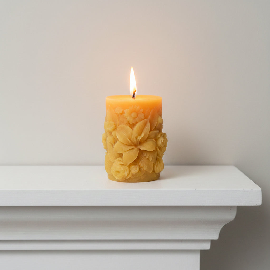scented sculpted beeswax pillar candle burning on fireplace mantel