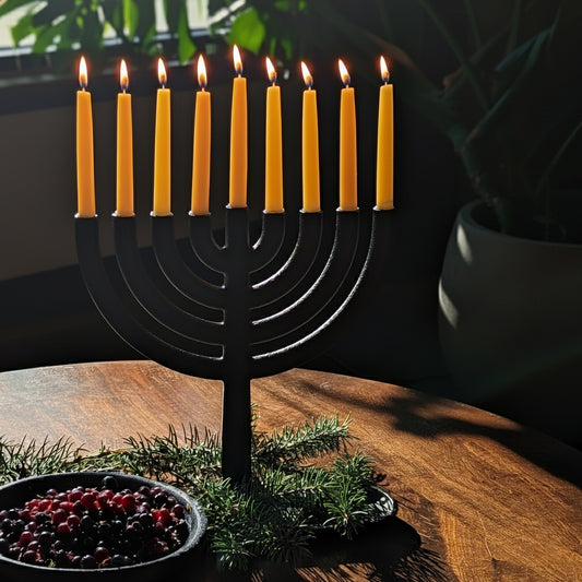 Bluecorn Beeswax - Pure Beeswax Hanukkah candles in black cast iron menorah on top of a table with greenery