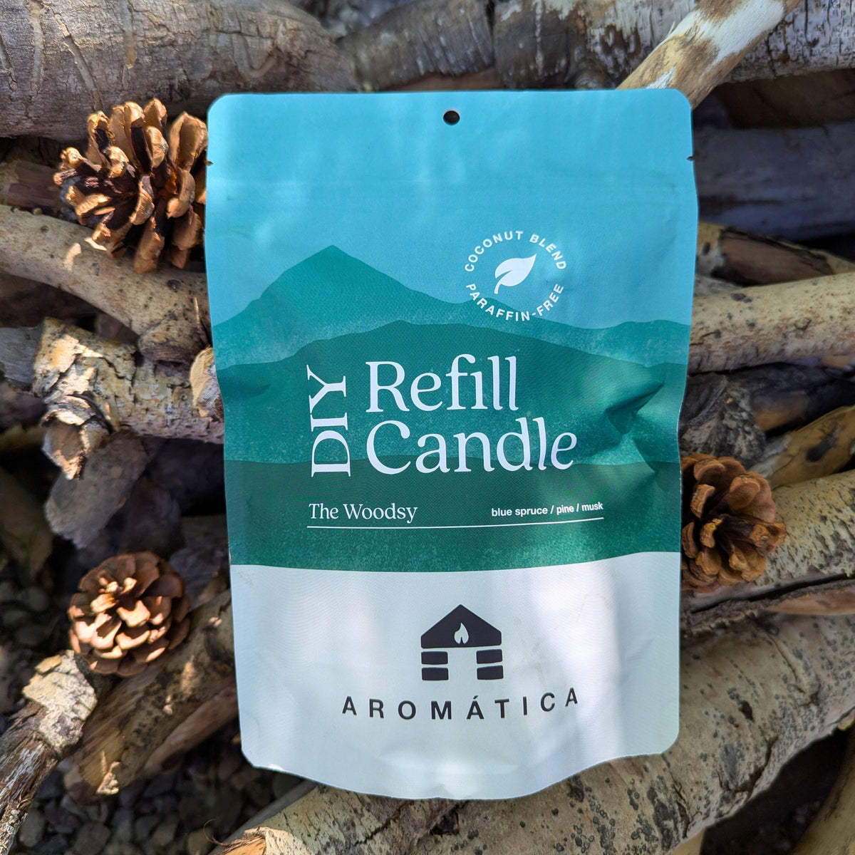The Woodsy scented Bluecorn Aromática DIY refill kit on a wooden background with pinecones