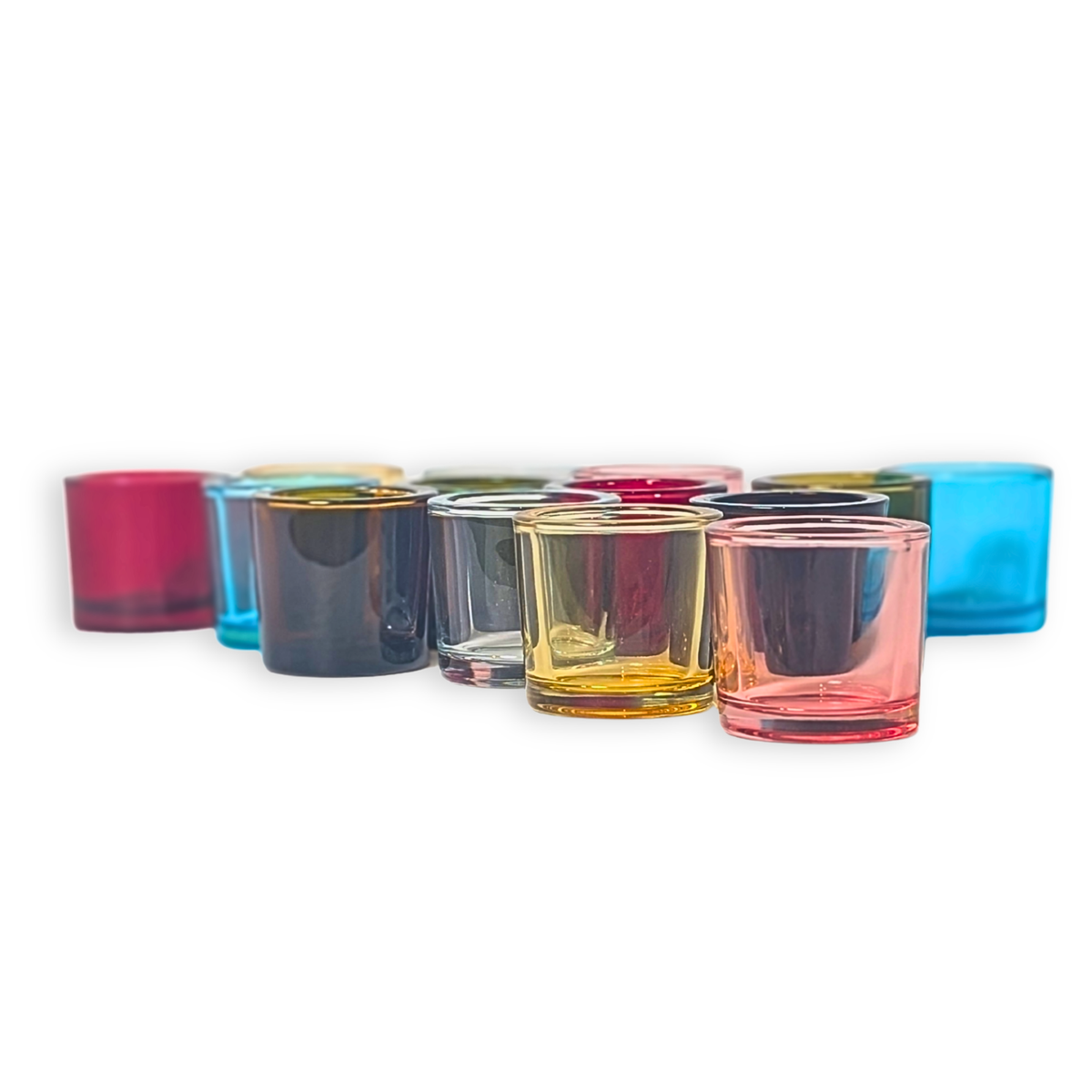 A set of heavy glass votive candle holders in light pink, blue, red, dark green, dark brown and clear with a white background