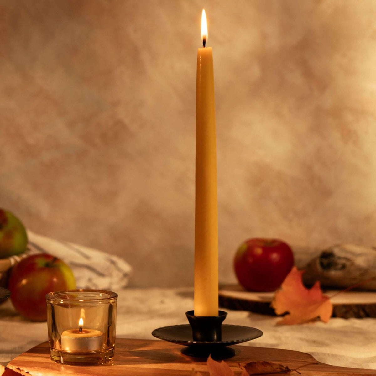 Hand-Dipped Beeswax Taper Candles - Bulk 4-Pair Bundle with a glowing taper and warm autumn decor.