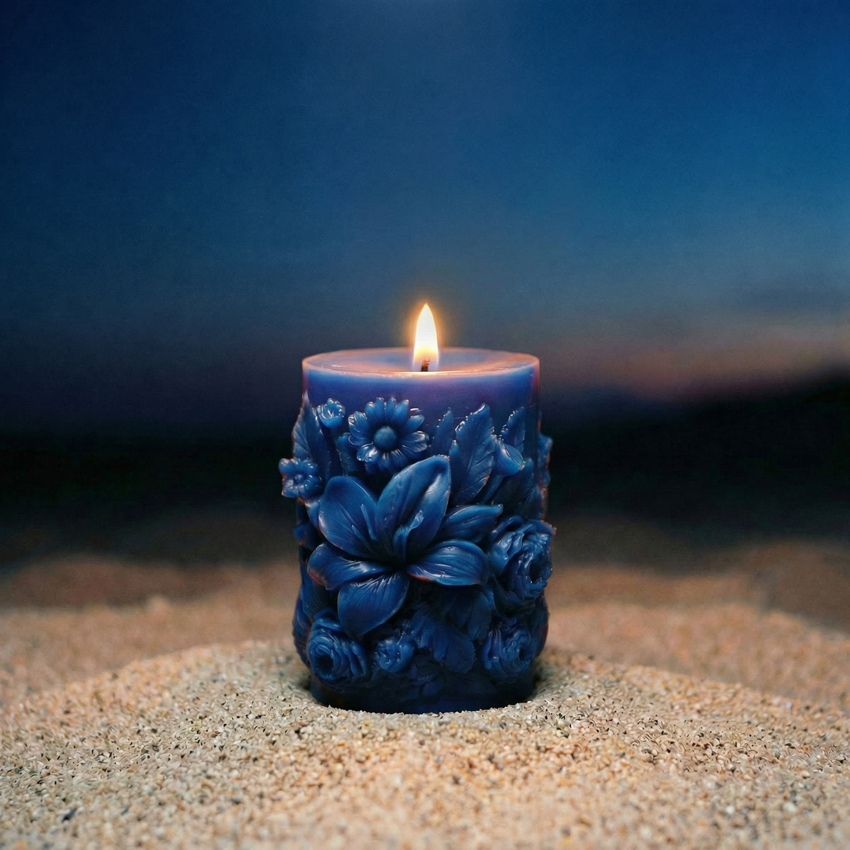 Lit, cobalt blue Sculpted Floral Design Beeswax Pillar Candle 