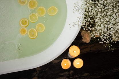 Ivory beeswax pillar candles beside a bathtub