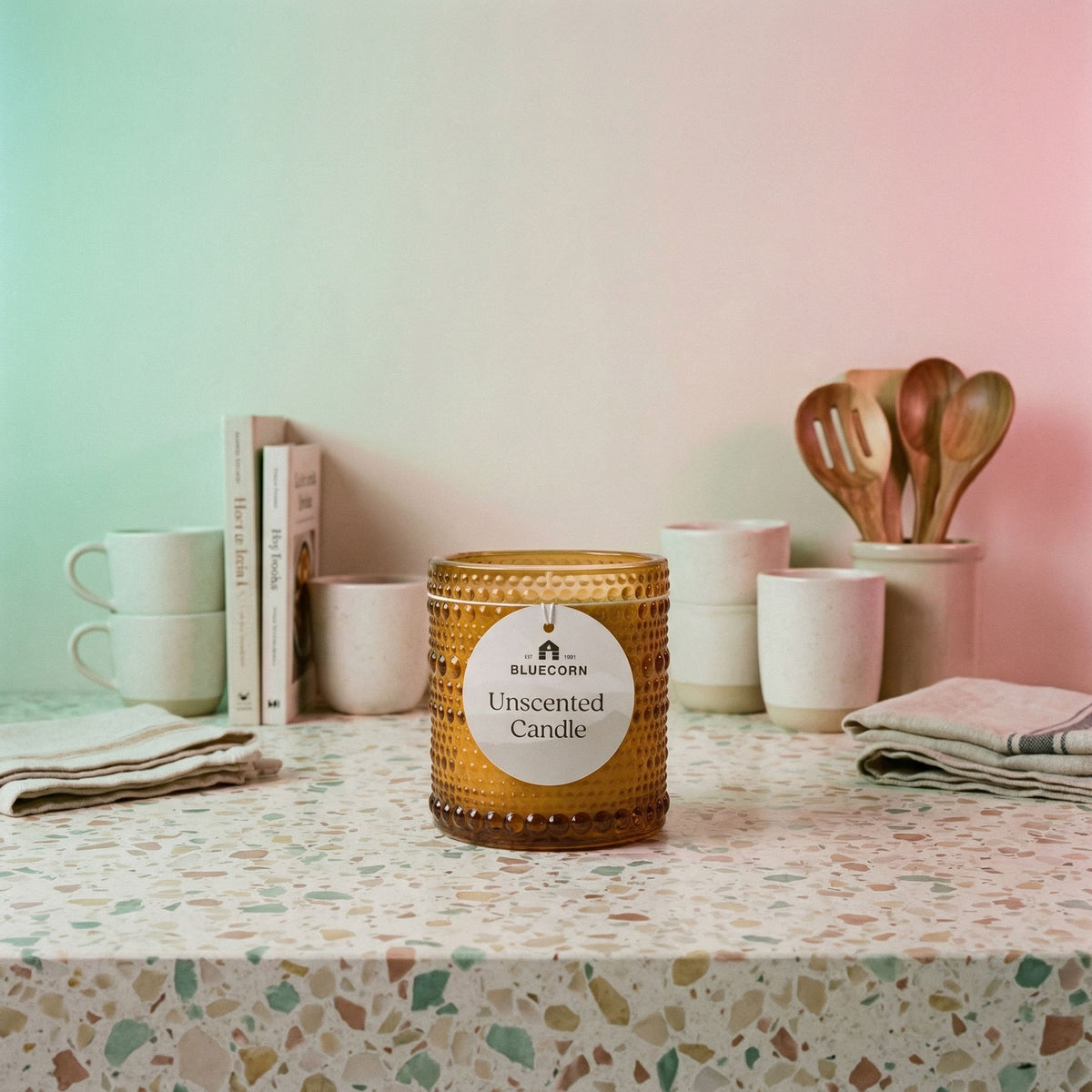 Unscented candles Coconut Wax Candles in amber glass on a tabletop with kitchen utensils and mugs.