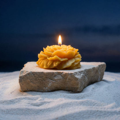 Lit, yellow raw peony shaped candle