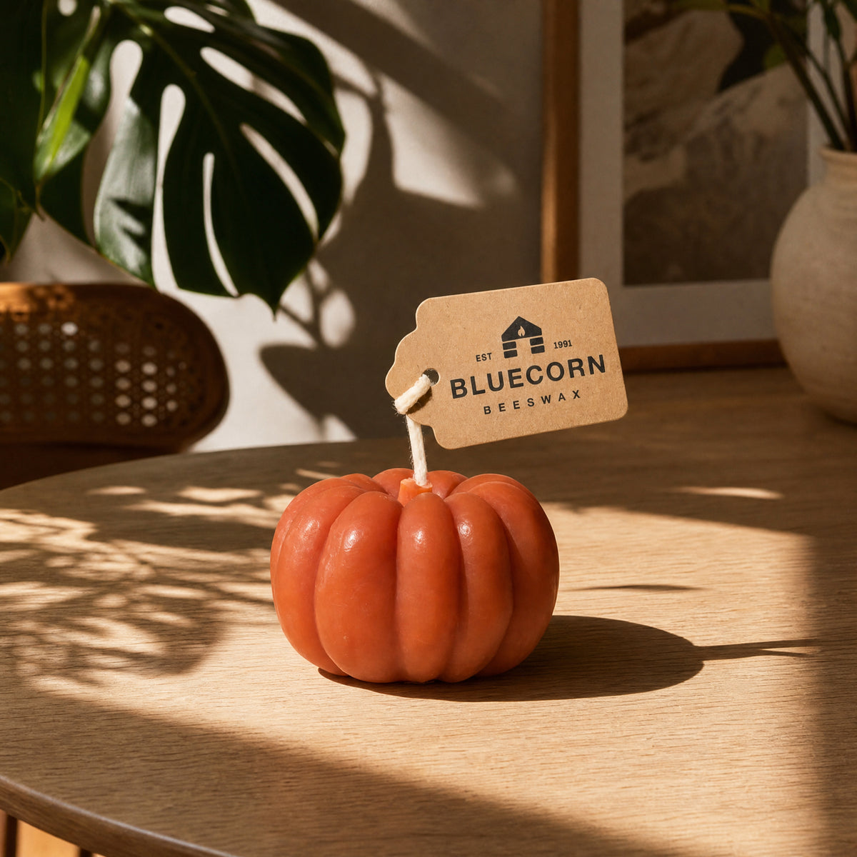 Scented beeswax pumpkin shaped candle from Bluecorn Candles in a fall decor setting