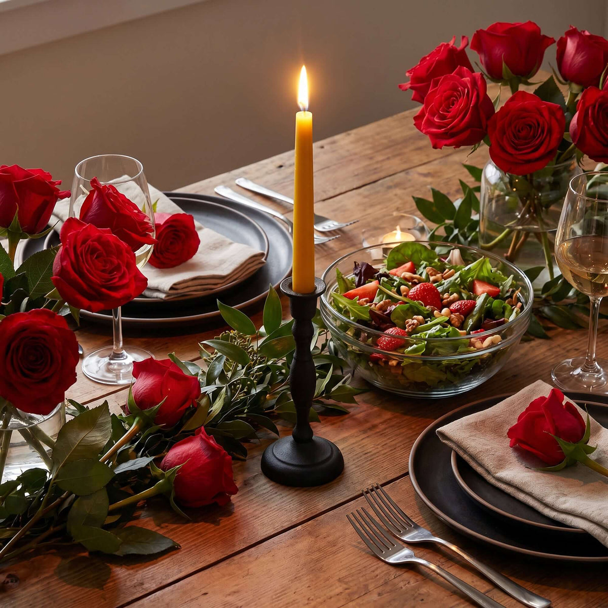 Elegant dining setting featuring hand-dipped beeswax taper candles and fresh red roses.