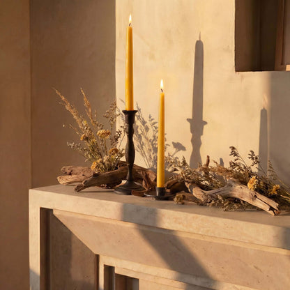beeswax taper candles displayed in a rustic setting with natural decor and warm lighting.