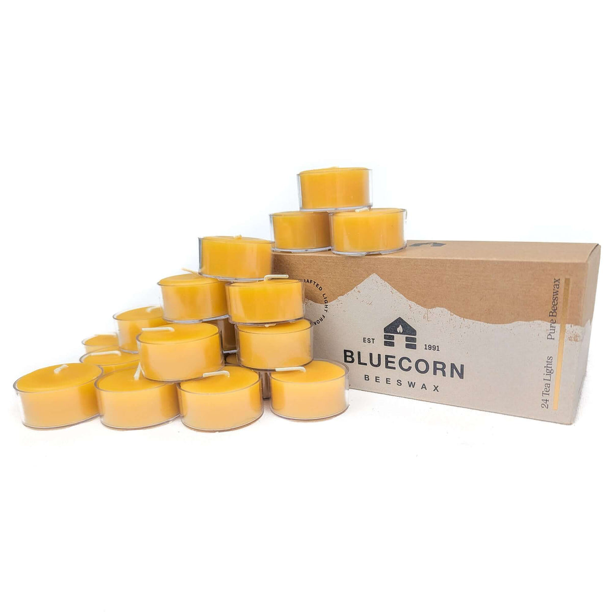 Bluecorn Beeswax 24-pack pure beeswax tea light candles in clear cups with bluecorn branded box and raw beeswax tea lights stacked around the box