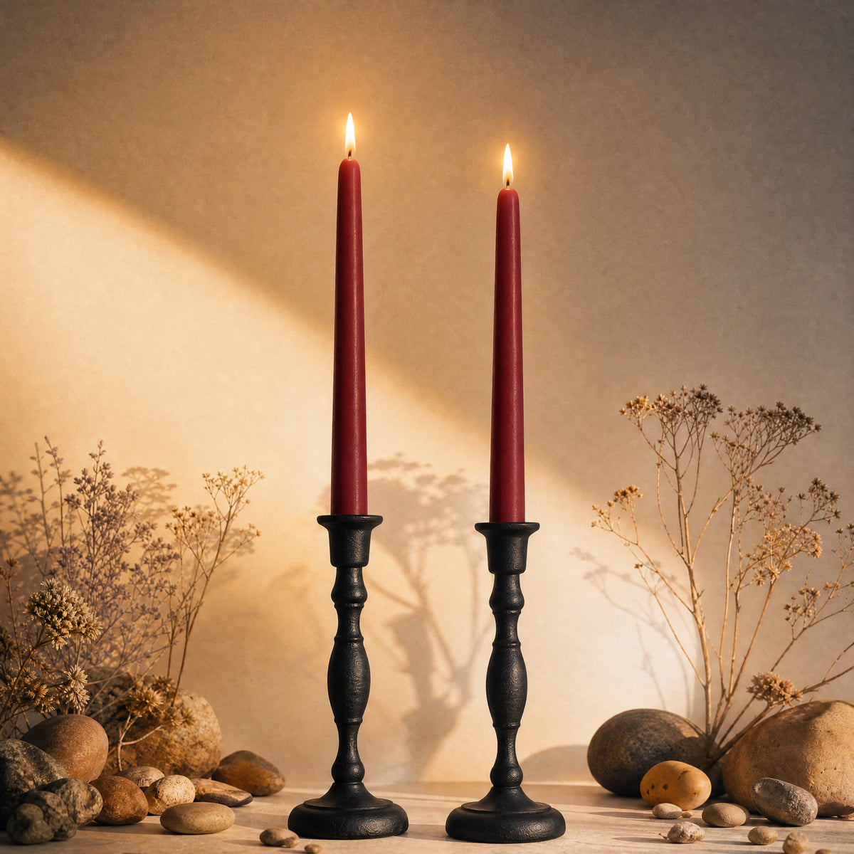 two burgundy beeswax taper candles in cast iron holders