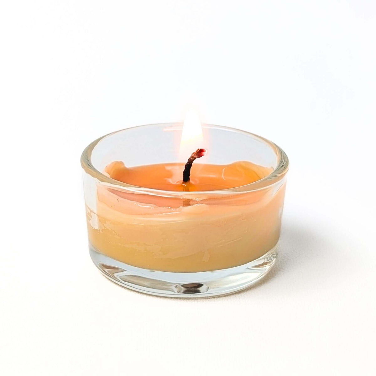pure bee wax tea light burning in refillable glass holder 