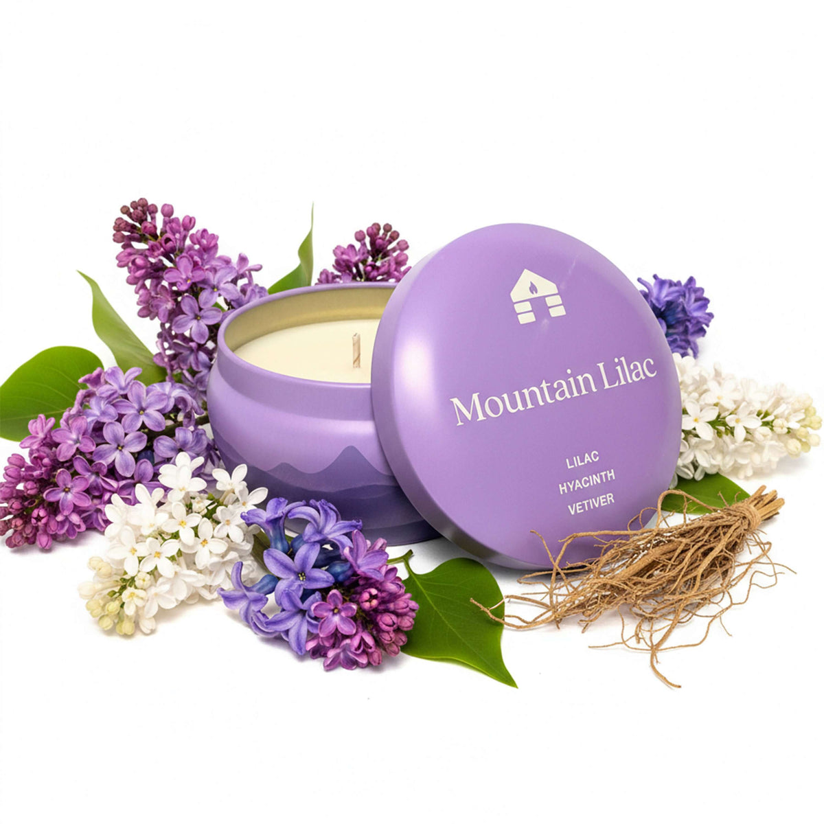 Bluecorn Aromática 8oz Mountain Lilac scented candle tin surrounded by lilac flowers on a white background
