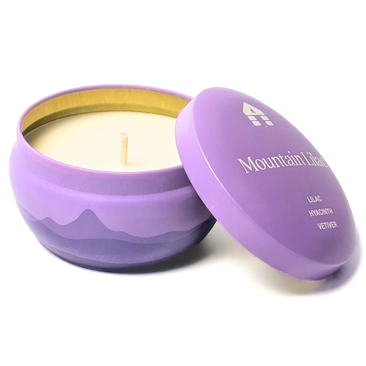 A Bluecorn Aromática 8oz Mountain Lilac scented candle tin with the lid taken off showing the wick and wax with white background