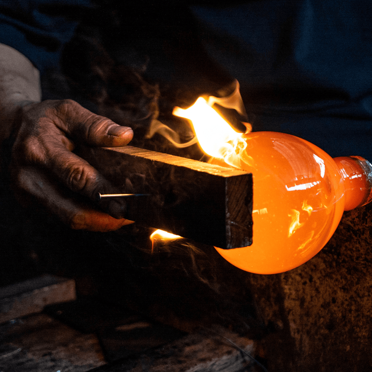 Blown glass being shaped by hand, showcasing craftsmanship in creating beautiful, custom refill candles.