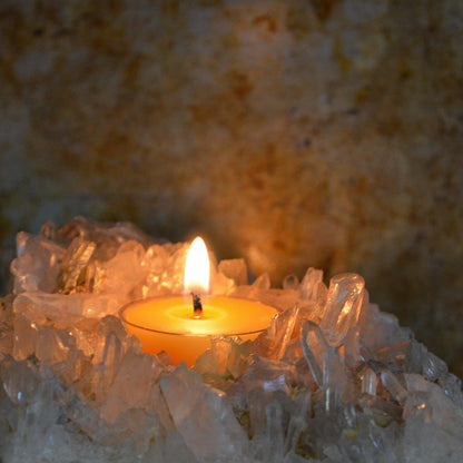 Bluecorn Beeswax Raw Tea Light burning inside of a crystal tea lights holder. Wax is golden in color and shows through the clear cup that it is in. beeswax tealight candles handmade in the usa