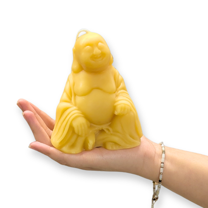 Raw beeswax buddha candle in hand to show size