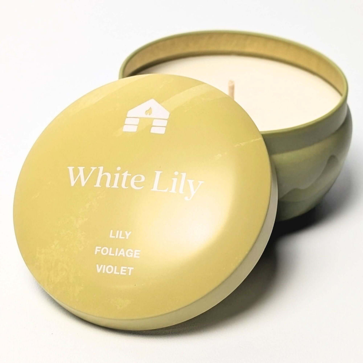 A Bluecorn Aromática 8oz White Lily scented candle tin with the lid taken off showing the wax with white background